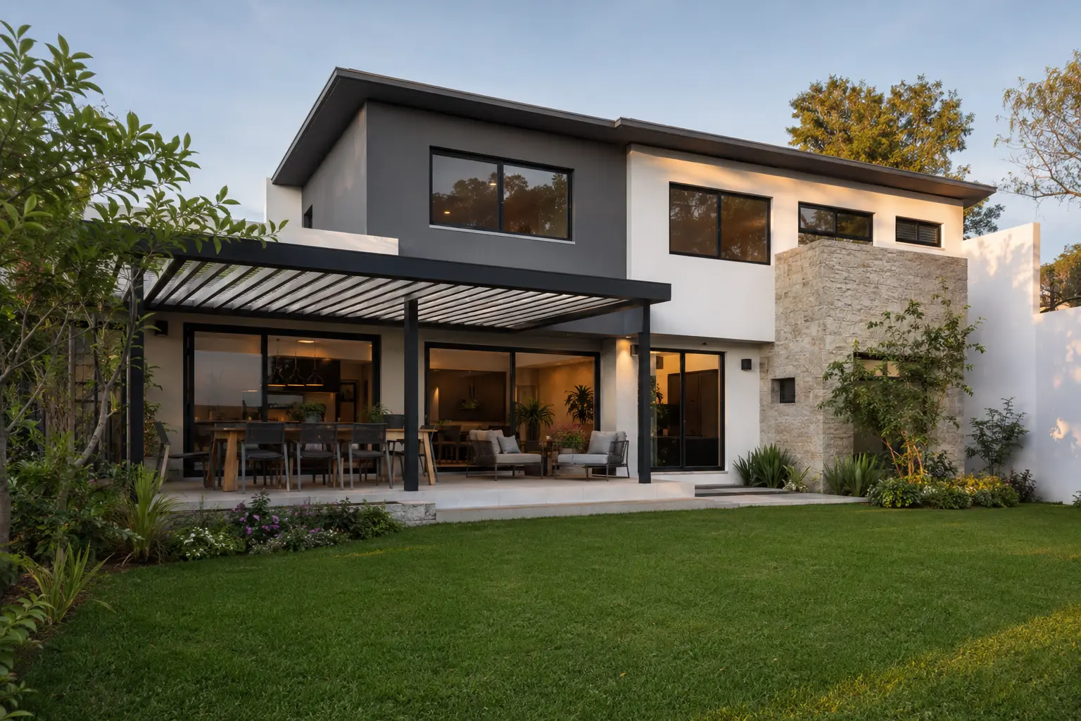 Casa contemporánea remodelada con fachada gris, piedra y pérgola
